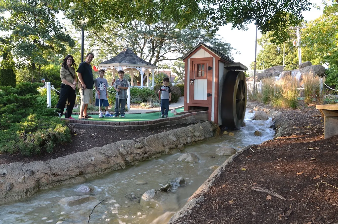 A family putting near the windmill and babbling brook